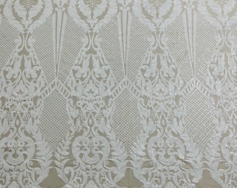 White shiny sequin damask design on a nude 4 way stretch mesh-sold by the yard.