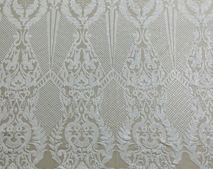 White shiny sequin damask design on a nude 4 way stretch mesh-sold by the yard.