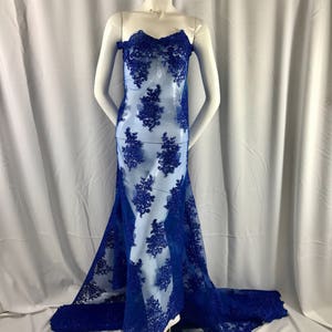 Puede incluir: Tela de encaje azul real con un patr&oacute;n floral. El encaje es delicado y tiene una textura suave y fluida.