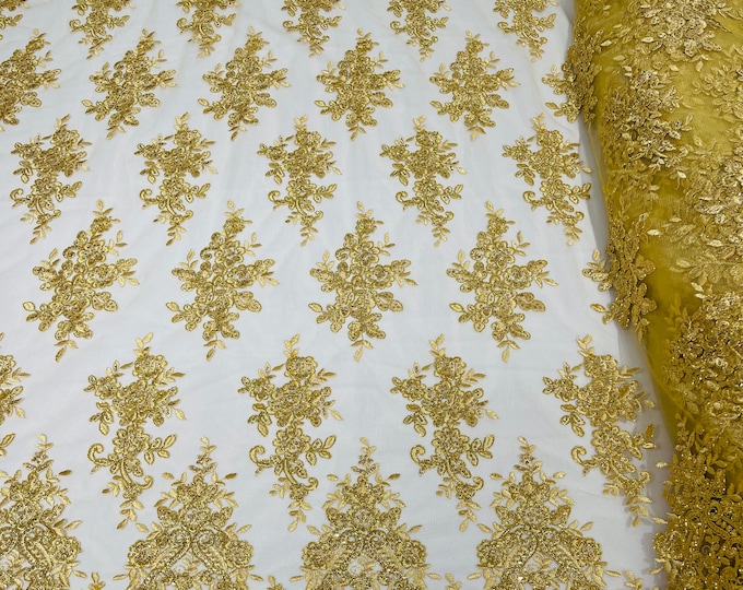 Gold Metallic floral design embroidery on a mesh lace with sequins and cord-sold by the yard.