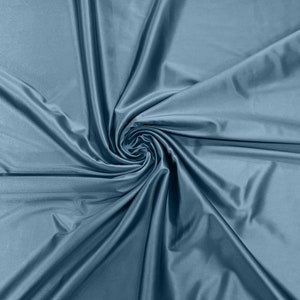 May include: A close-up of a smooth, blue fabric with a swirling pattern. The fabric is soft and luxurious, with a subtle sheen.