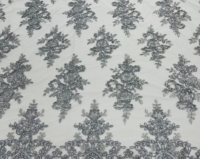 Silver corded flowers embroider with sequins on a mesh lace fabric-sold by the yard.