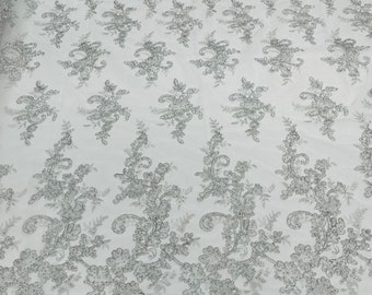 White/silver metallic Gomez Floral design corded embroider with sequins on a mesh lace fabric-sold by the yard.