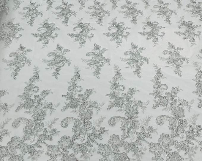 White/silver metallic Gomez Floral design corded embroider with sequins on a mesh lace fabric-sold by the yard.