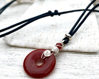 A small  20mm red carnelian donut pendant, black adjustable necklace choker, wire wrapped in silver