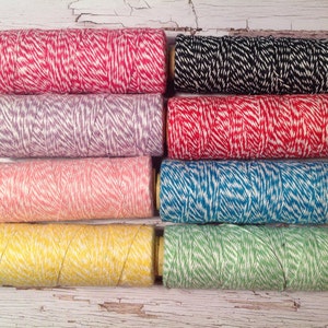 May include: Eight spools of twine with white and colored stripes. The colors are red, purple, pink, blue, yellow, and green.
