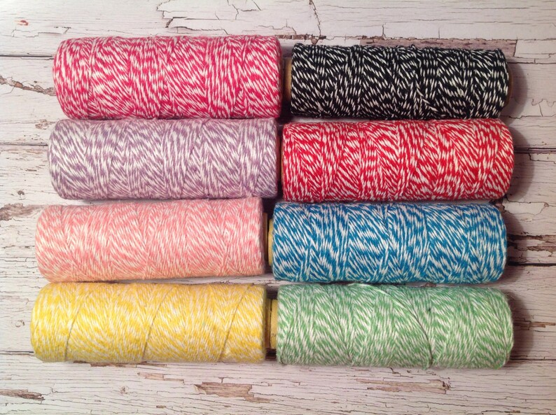 May include: Eight spools of twine with white and colored stripes. The colors are red, purple, pink, blue, yellow, and green.