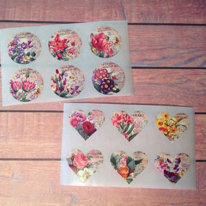 Peut inclure: Deux feuilles d'autocollants avec des motifs floraux. La premi&egrave;re feuille comporte six autocollants ronds avec diff&eacute;rents motifs floraux. La deuxi&egrave;me feuille comporte six autocollants en forme de c&oelig;ur avec diff&eacute;rents motifs floraux.