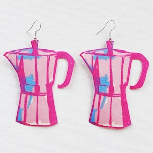 May include: A pair of pink and blue patterned earrings shaped like coffee pots.