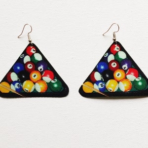 Könnte beinhalten: Ein Paar dreieckige Ohrringe mit einem bunten Bild eines Billardtisches mit Billardkugeln und einem Queue. Die Ohrringe sind aus Holz und haben silberne Haken.