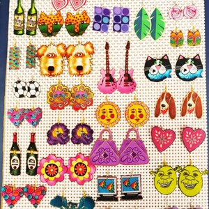 Pode incluir: Uma cole&ccedil;&atilde;o de brincos de madeira pintados &agrave; m&atilde;o e coloridos. Os brincos apresentam v&aacute;rios desenhos, incluindo gatos, c&atilde;es, guitarras, flores, cora&ccedil;&otilde;es e muito mais.