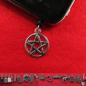 Può includere: Ciondolo d'argento con un design a pentagramma, appeso a un cordino nero. Il ciondolo è attaccato a una custodia per cellulare nera.