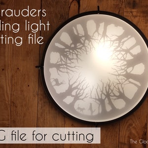 Op de afbeelding: Een witte plafondlamp met een zwart metalen frame. De lamp heeft een cirkelvormig ontwerp met een uitgesneden patroon van bomen. De tekst "Marauders ceiling light cutting file" staat boven de lamp. De tekst "SVG file for cutting" staat onder de lamp. De tekst "The Gloomy Light" staat in de rechterbenedenhoek van de afbeelding.