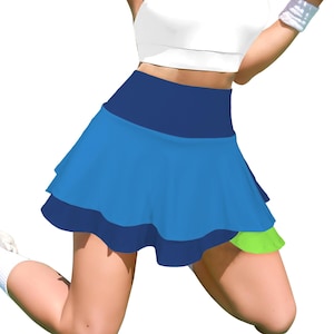 May include: A high-waisted athletic skirt featuring a wide dark blue waistband, a layered design with a bright blue middle tier, a dark blue bottom tier, and a small lime green accent panel visible on the lower left side of the garment.