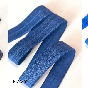 Puede incluir: Tres rollos de tejido el&aacute;stico en colores carb&oacute;n, azul marino y azul cobalto. Cada rollo tiene un brillo sutil y est&aacute; doblado por la mitad.