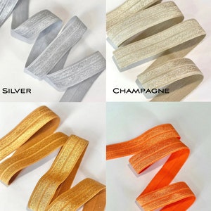 Puede incluir: Cuatro rollos de cinta el&aacute;stica con un acabado brillante. Los colores son plata, champ&aacute;n, co&ntilde;ac y naranja.