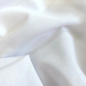 Puede incluir: Primer plano de tela blanca con pliegues suaves y textura sutil. La tela parece ligera y fluida, con luces y sombras que crean profundidad. La impresión general es de un textil liso y limpio.