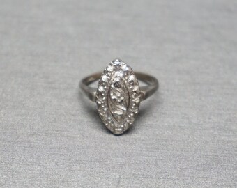Op de afbeelding: Een zilveren ring met een marquise-vormige zetting met een delicaat bloemenmotief.