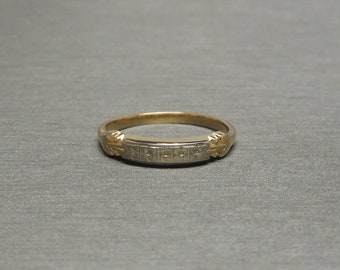 May include: A gold and silver band ring with a textured design. The ring has a simple, elegant style.