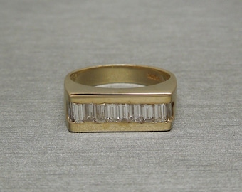 May include: A gold band ring with a row of baguette-cut diamonds set in a rectangular channel.