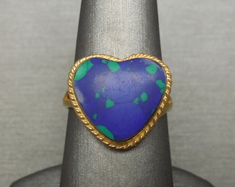 May include: A gold ring with a heart-shaped blue and green gemstone.