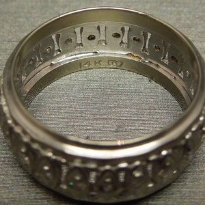 May include: A silver ring with a decorative design and the inscription "14K G" on the inside.