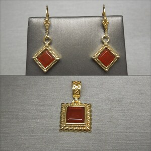 May include: A set of gold earrings and a pendant featuring square carnelian stones set in a gold frame with a rope-like design.