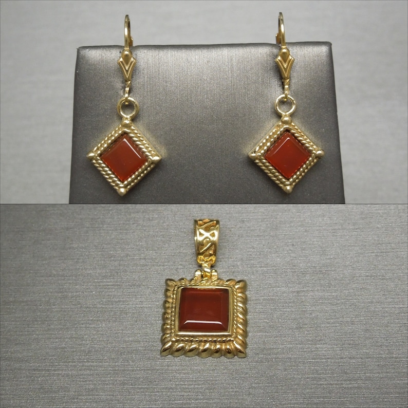 May include: A set of gold earrings and a pendant featuring square carnelian stones set in a gold frame with a rope-like design.