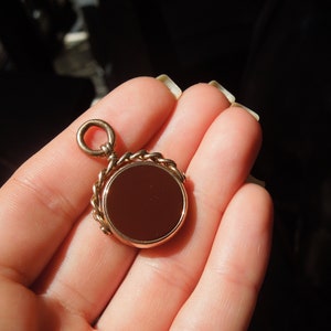 May include: A gold-toned fob chain with a round, red carnelian stone pendant.