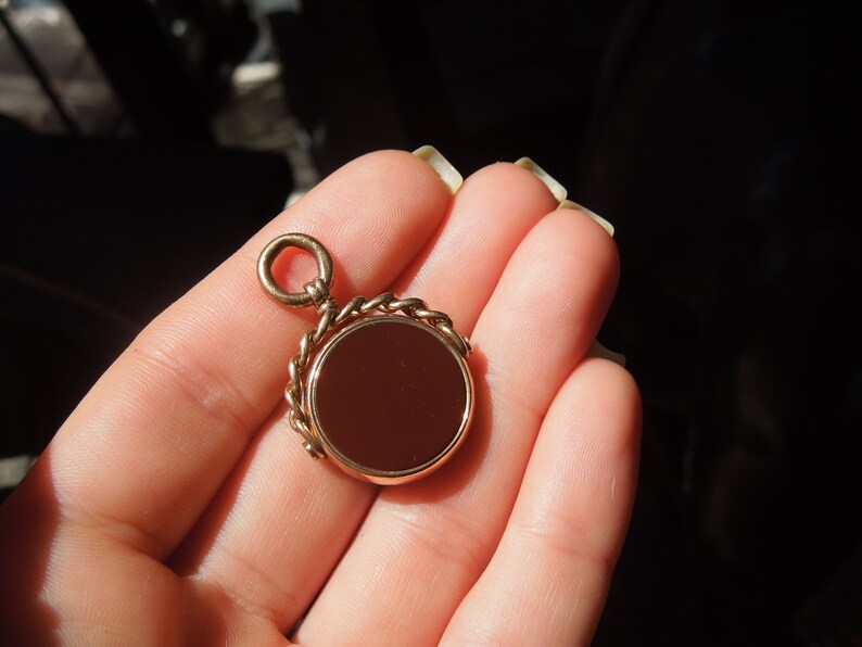 May include: A gold-toned fob chain with a round, red carnelian stone pendant.