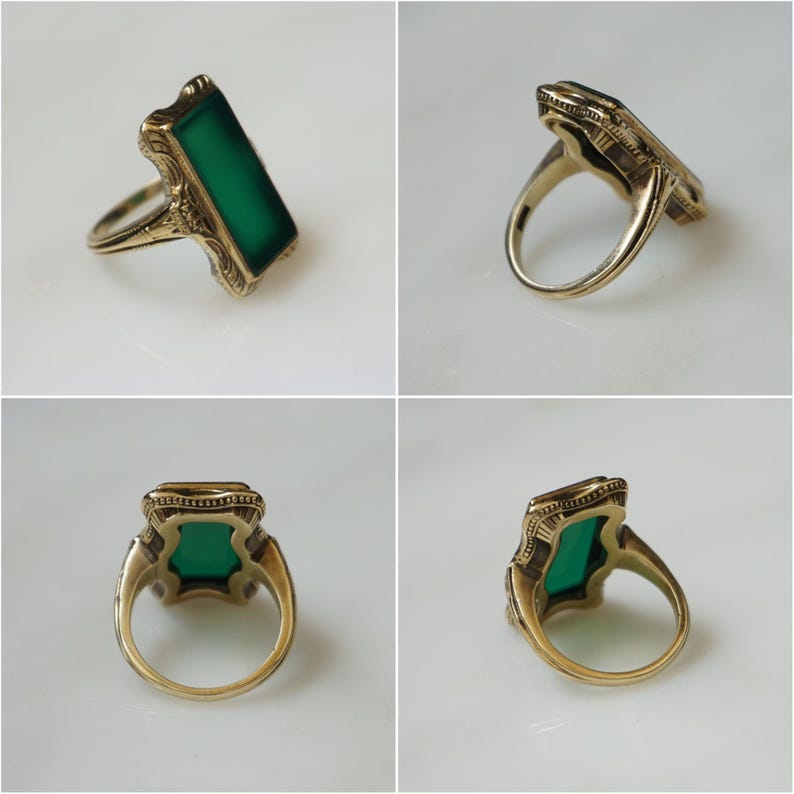 May include: A gold ring with a green rectangular stone set in a filigree design.