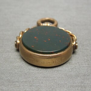 May include: A gold fob seal with a green and red cameo. The back of the seal is engraved with the number "31731617".