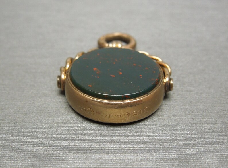 May include: A gold fob seal with a green and red cameo. The back of the seal is engraved with the number "31731617".