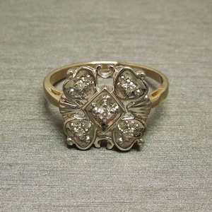May include: A gold ring with a five-pointed star design set with small diamonds.