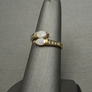 K&ouml;nnte beinhalten: Ein goldener Ring mit zwei birnenf&ouml;rmigen Opalen und einer Reihe kleiner Diamanten.
