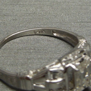 May include: A silver ring with a detailed design and the inscription "14K" on the inside band.