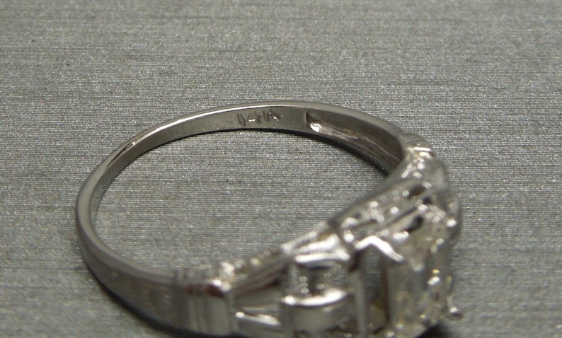 May include: A silver ring with a detailed design and the inscription "14K" on the inside band.