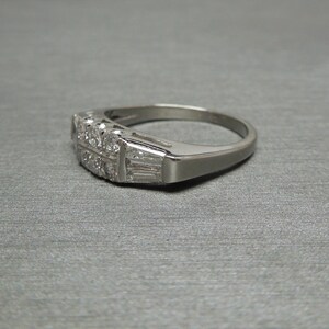 May include: A silver band ring with a row of small diamonds and a row of baguette diamonds.