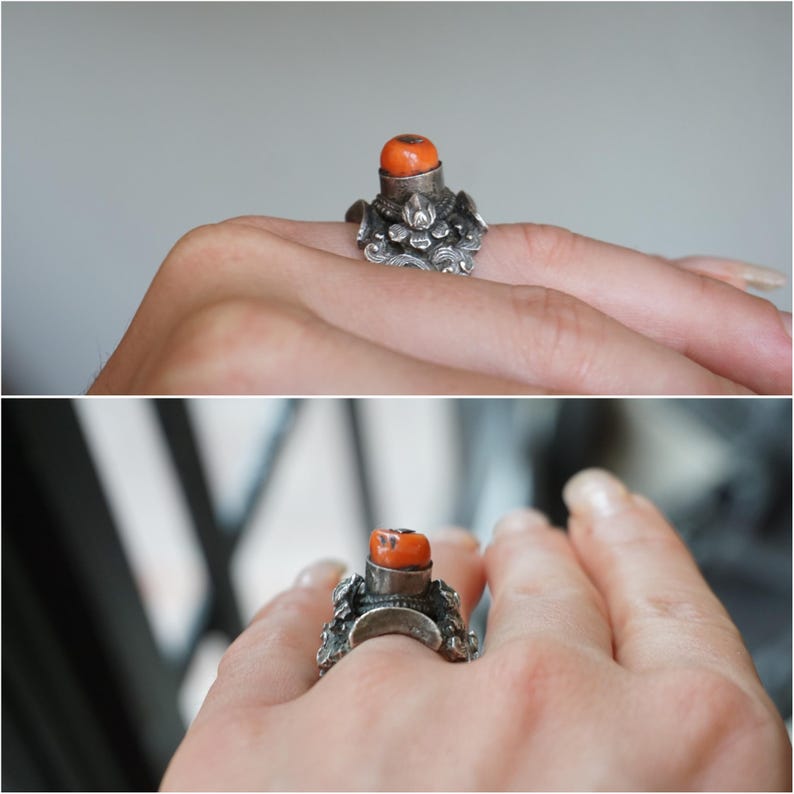 May include: A silver ring with an orange coral stone set in a detailed design.