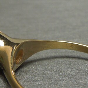May include: A gold ring with a large, light blue gemstone set in a prong setting.