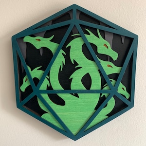 Op de afbeelding: Een driedimensionaal drakenbeeld van groen hout in een blauw, geometrisch houten frame. Het beeld is gemaakt van gelaagd hout en heeft een gedetailleerd ontwerp.