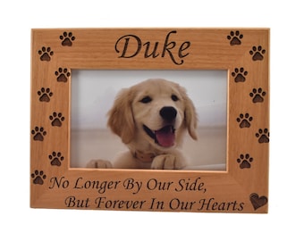 May include: Wooden photo frame with a paw print border. The frame has the name "Duke" engraved on the top and the text "No Longer By Our Side, But Forever In Our Hearts" engraved on the bottom. A photo of a golden retriever puppy is in the frame.
