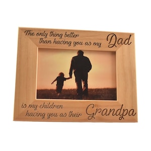 May include: A wooden picture frame with an engraved message that reads "The only thing better than having you as my Dad is my children having you as their Grandpa". The frame has a photo of a father and son walking away from the camera in a field.