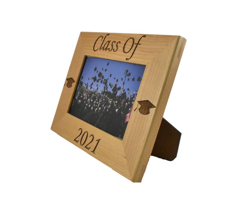 Op de afbeelding: Een houten fotolijst met een afstudeerhoedontwerp en de tekst "Class of 2021".