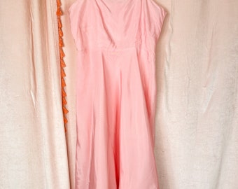 May include: A light pink sleeveless dress with a square neckline and a flowy skirt.