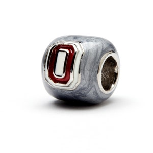 May include: A silver charm bead with a red and white enamel Ohio State University logo.