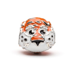 May include: A silver charm bead with an orange and black enamel tiger face design. The bead is white with black outlines and has a glossy finish.