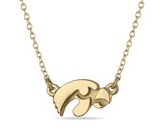 May include: A gold chain necklace with a small gold pendant shaped like a hawk's head.