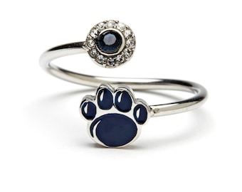 May include: A silver ring with a blue paw print and a clear crystal stone surrounded by smaller crystals.