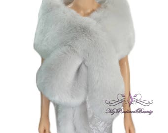 May include: A soft, light gray faux fur shawl. The shawl is draped over a mannequin's shoulders and is styled to show the length and drape of the fabric.